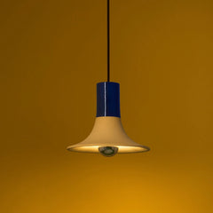 Wine Pendant Light lit, cream ceramic flared shade with glossy navy blue neck, close-up