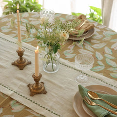 Mirage Pistachio Linen Table Runner on dining table with brass candlesticks and wildflowers
