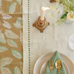 Mirage Pistachio Linen Table Runner with brass candlestick and embroidered border, top view