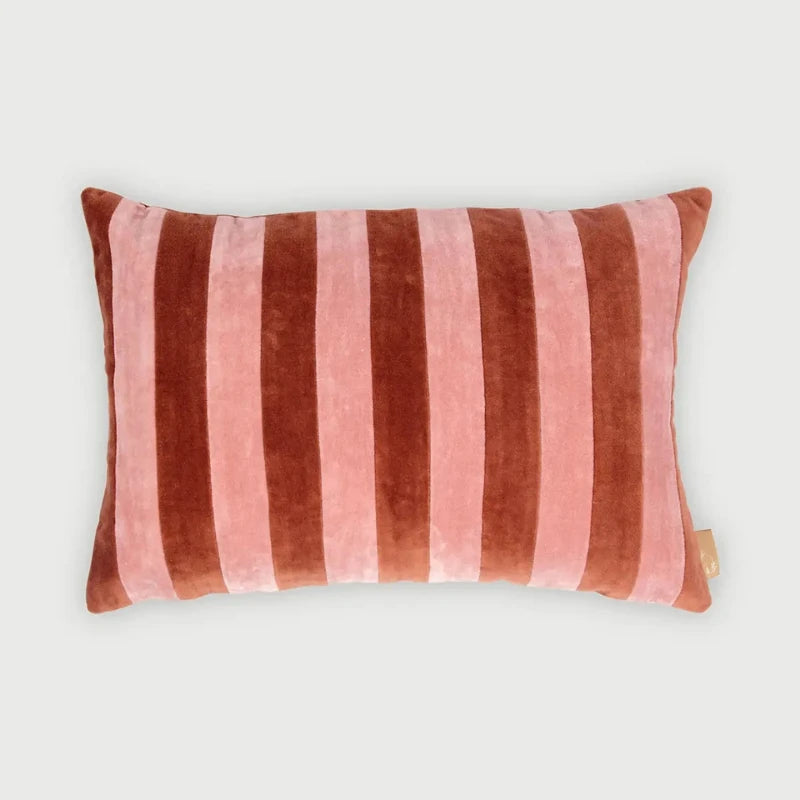 A rectangular velvet lumbar pillow with vertical stripes in dusty rose pink and dark reddish-brown, shown on a light gray background.