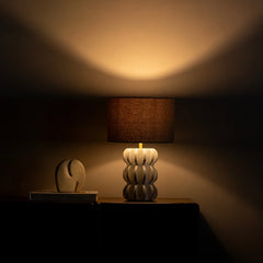 Decorative Spar Table Lamp on a table casting a warm glow in a dimly lit room.