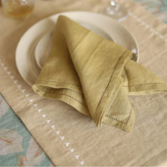 Mirage Sand Linen Table Runner with plate and folded olive napkin, close view