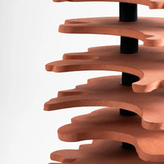 Wooden spiral shelf with a black central post on a white background