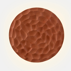 A brown terracotta and steel wall light fixture designed with a geometric pattern.