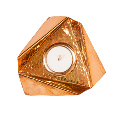 A copper plated brass Origami Tealight holder with a hammered texture and a candle inside, reflecting on the copper surface.