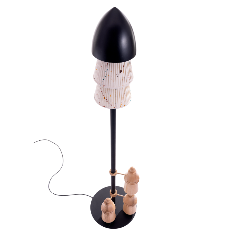 A floor lamp with a black shade and a teak wood top, featuring a lamp base with a mix of materials and a chain of wood elements extending downwards.