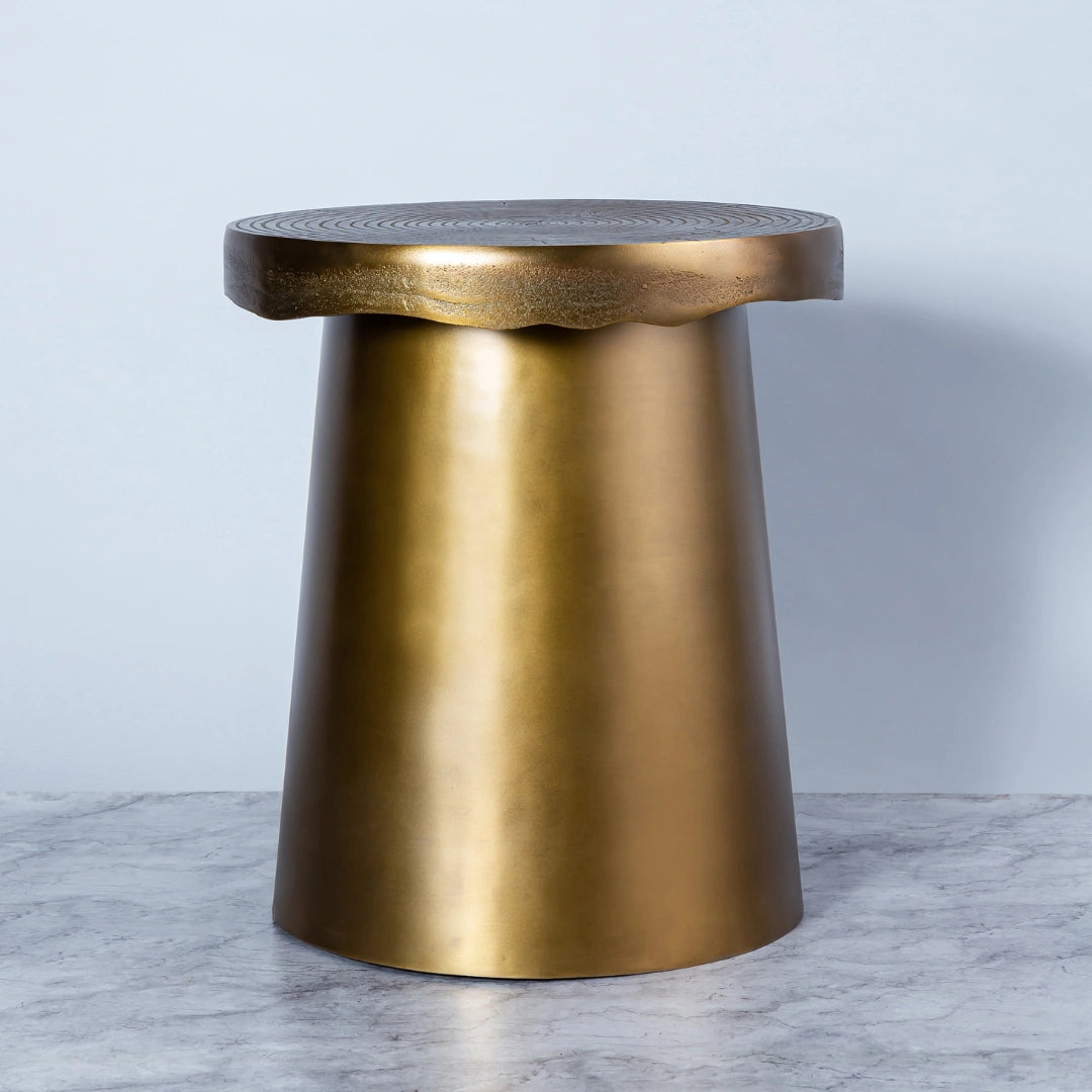 An irregularly shaped side table with an antique brass finish, derived from the terrain inspiration, with a smooth finish on top.
