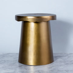 An irregularly shaped side table with an antique brass finish, derived from the terrain inspiration, with a smooth finish on top.