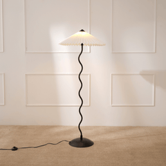 A Wavy Floor Lamp with a handpleated paper shade and a powder-coated metal base