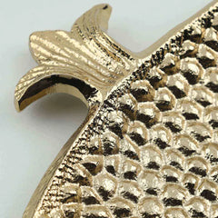Close-up of a textured gold pomegranate motif Roma tray on a light gray background