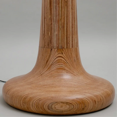 Close-up of a tall wooden floor lamp base on a neutral background
