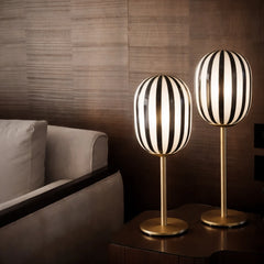Two modern Bullseye Table Lamp with black and white striped shades on a wooden surface.