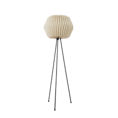 A modern floor lamp with a white origami-inspired linen shade and a black knock-down tripod stand with decorative elements on the legs.