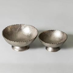 Two silver arc bowls with textured surfaces on a light gray background