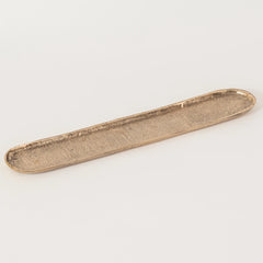 Long, narrow dosa tray in bronze color with textured surface on a light gray background