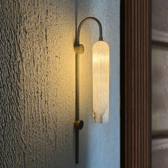 Lune Rise Alabaster Wall Light with ambient lighting on a textured wall