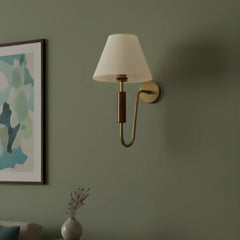 Wall-mounted Resort Wood Elegance Wall Lamp with a white shade on a green wall with abstract art and a vase.