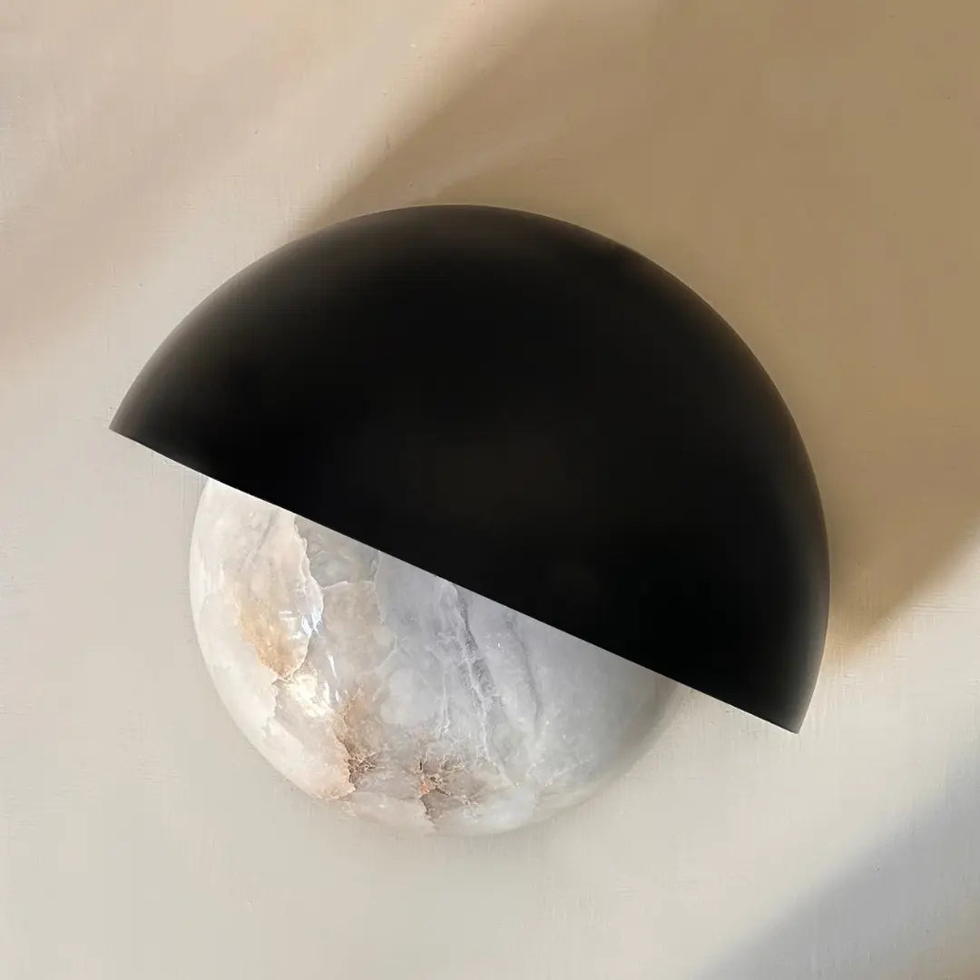 Half Moon Wall mounted light fixture with black semi-circular shade on a neutral background