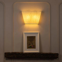 Designer Munich Wall-mounted light fixture casting a warm glow on a wall with a framed picture below.