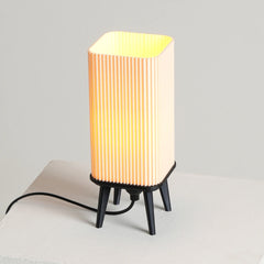 Small dawn table lamp with a ribbed design on a light gray background
