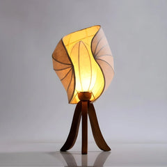 Decorative Kosh Table Lamp with a unique shade, warm glowing light on a gray background