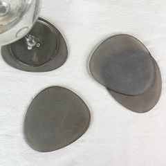Brown Frosted Glass Coasters Set of 4 on a white surface with a glass of water