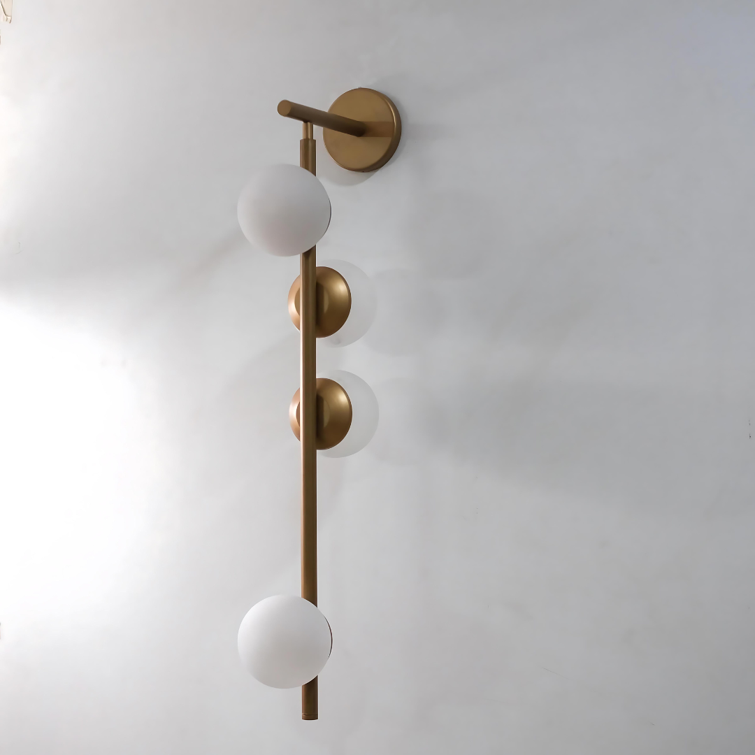 A wall-mounted industrial garage lamp with frosted glass shades and a gold matte finish, mounted on a plain wall.