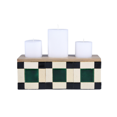 Decorative Blade of Grass candle holder with checkered design and three white candles on a white background
