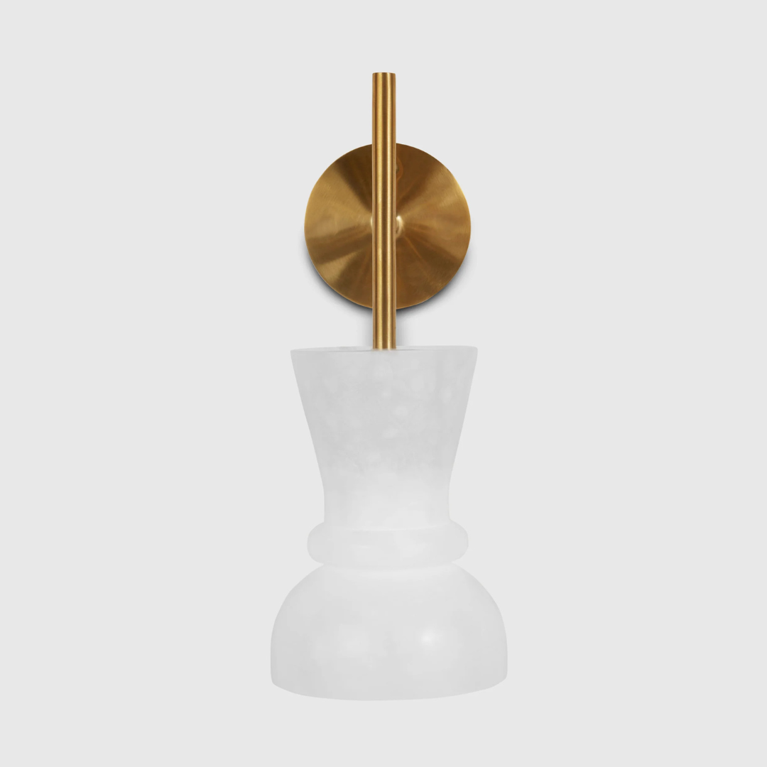 A wall-mounted light fixture with a white alabaster shade and a brass steel base.