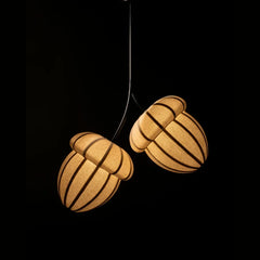 Two acorn-shaped pendant lamps hanging against a black background