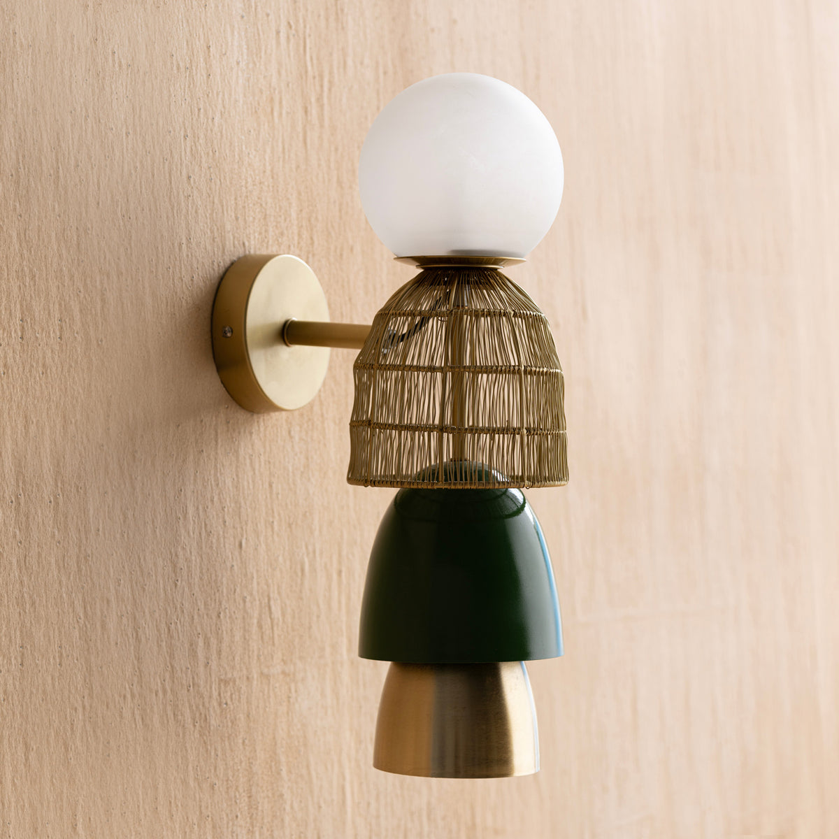 Totem Gold Wall Lamp- wall-mounted lamp with a gold-colored base and a woven basket-like shade.