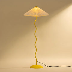 Wavy Floor Lamp with white hand-pleated paper shade in butter yellow stand showing warm ambient glow