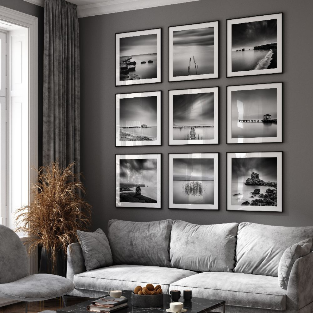 Black and white framed artwork 9 pieces on the wall with gray sectional sofa in a living room with