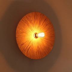 Decorative Vagu wall lamp, natural raffia woven wall light fixture casting a warm ambient glow