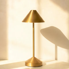 Gold portable table lamp on a neutral background