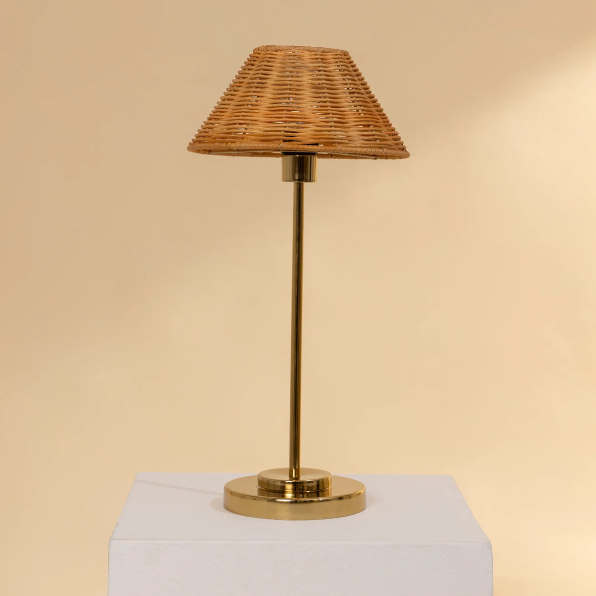 Natural Cane Table Lamp with wicker shade and brass base on a beige background