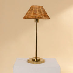 Natural Cane Table Lamp with wicker shade and brass base on a beige background