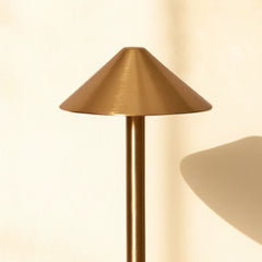 Gold Orbit Portable Lamp with a cone-shaped shade on a neutral background