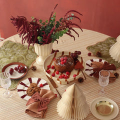 Rhubarb Velvet Napkin Rings in festive table setting with paper trees and cake, high angle