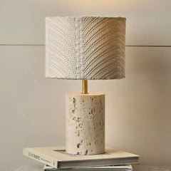 Terra Table Lamp - Lit, Travertine Base with Brass Stem on Stacked Books