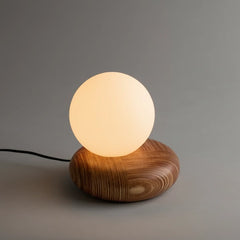 Wooden table lamp with a glowing round frosted glass bulb