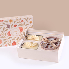 A cream-colored gift box set that includes Scented Memories Wax Tablet & Bowl Candle in a floral-patterned box lid.
