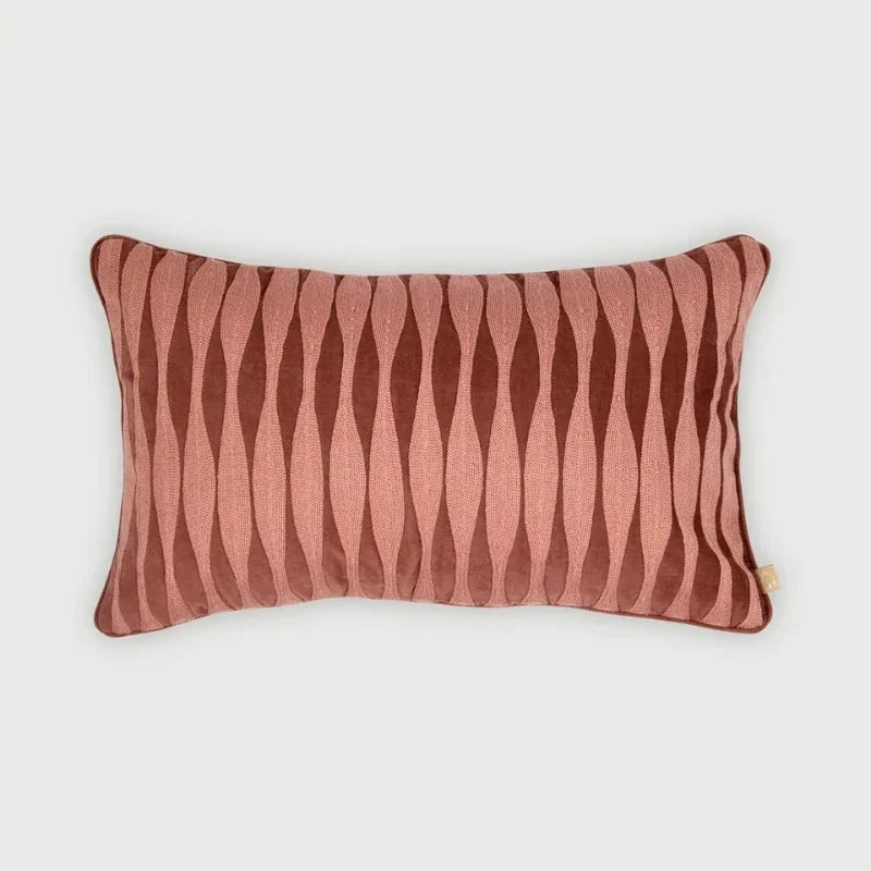 A rectangular lumbar throw pillow with a dusty rose and dark brown wavy vertical stripe pattern, shown against a light gray background.