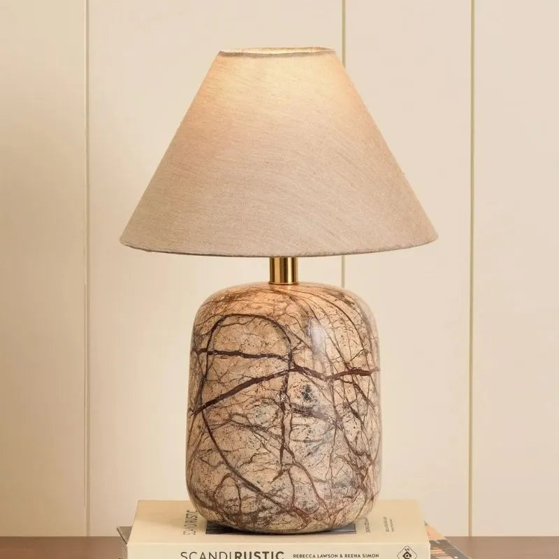 Dune Table Lamp - Lit, Linen Shade and Brown Veined Marble Base on Books