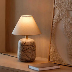 Dune Table Lamp - Glowing on Wooden Console Beside Textured Wall Art