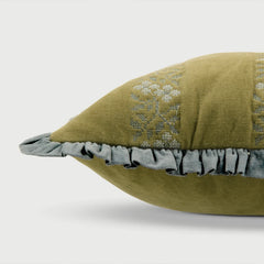 Green pillow with floral embroidery and gray ruffle on a white background