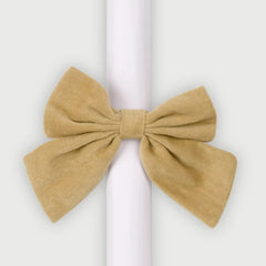Sand Velvet Napkin Rings single micro-velvet bow on white rolled napkin, front view
