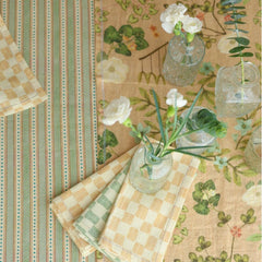 Valley Peach Linen Table Runner beside striped tablecloth with bud vases, overhead close-up