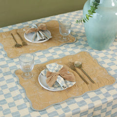Sand Velvet Napkin Rings on two quilted placemat settings with glassware, overhead view