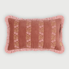 A rectangular decorative throw pillow in dusty rose velvet with vertical embroidered floral stripes in pink and gold, finished with a ruffled edge, shown on a light gray background.